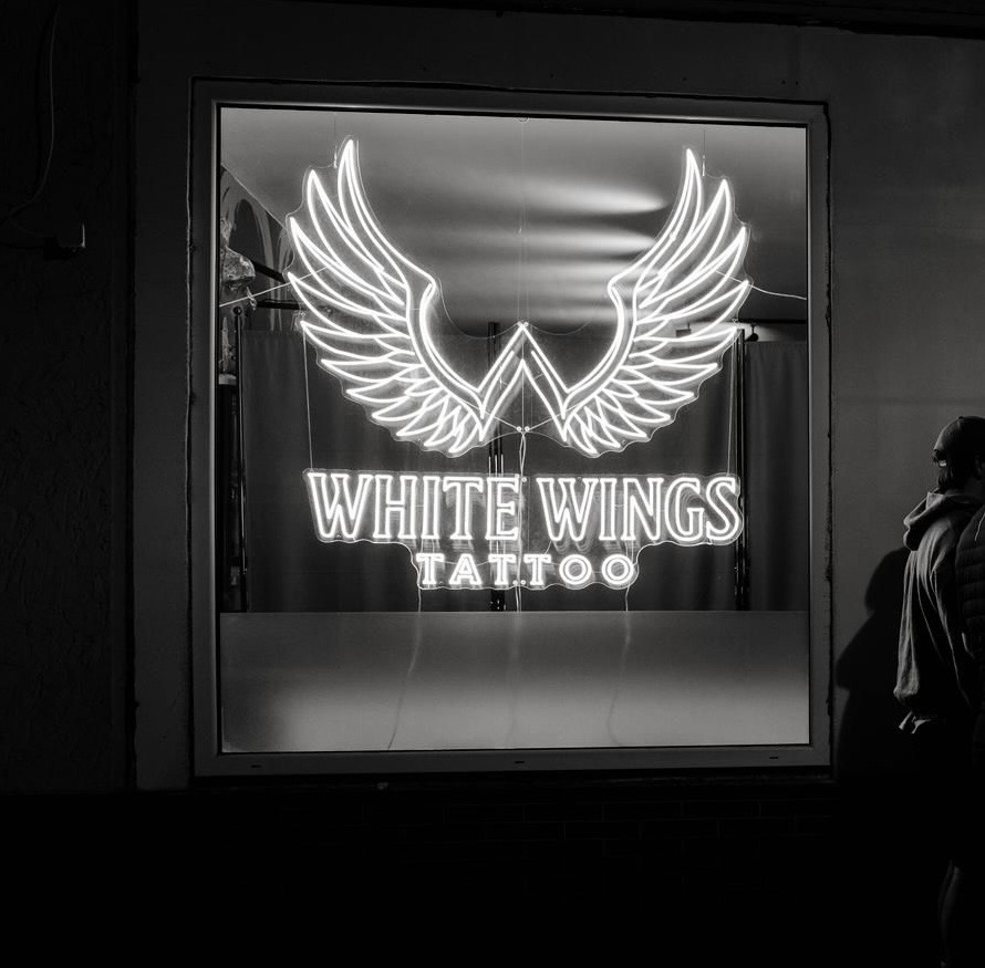 Leuchtendes White Wings Tattoo Studioschild